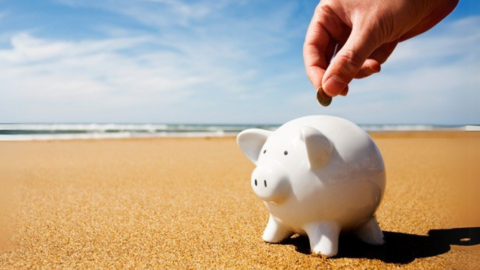 Spaarpot op het strand om vakantiegeld te sparen
