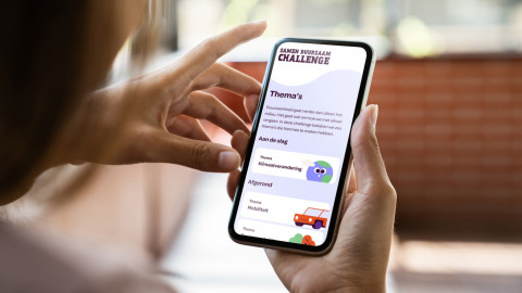Persoon bedient smartphone met app in heldere ruimte, scherm toont kleurrijke icoontjes.