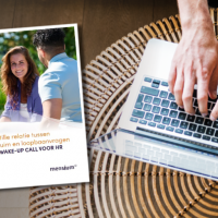 Brochure naast handen typend op een laptop met een glazen tafelblad.