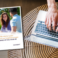 Brochure naast handen typend op een laptop met een glazen tafelblad.